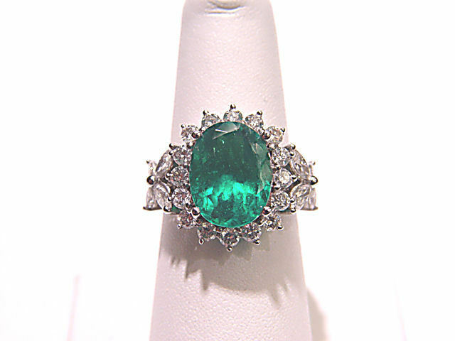 1 OVAL GREEN EMERALD 4.76 CT 18 K WHITE GOLD SET WITH ROUND BRILLIANT MARQUISE